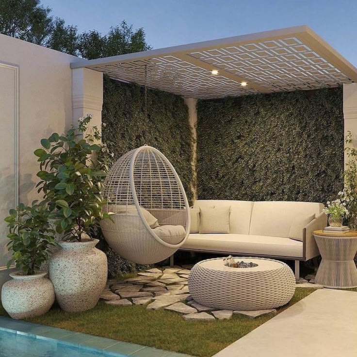 an outdoor living area with white furniture and greenery on the wall, next to a swimming pool