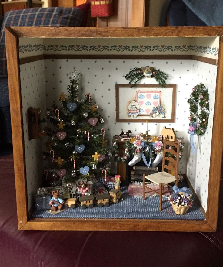 a miniature christmas tree in a wooden frame