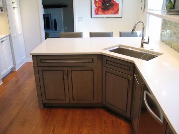 a kitchen with white counter tops and wooden floors