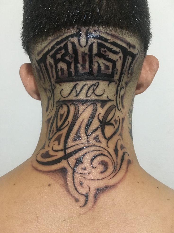 the back of a man's head with tattoos on his face and neck area