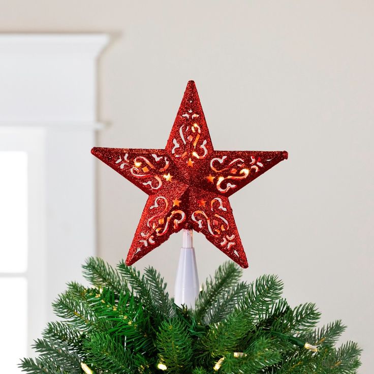 a red star decoration on top of a christmas tree