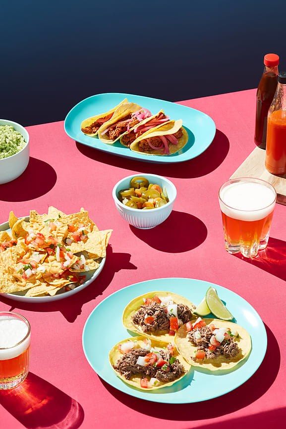 mexican food and drinks on a pink table