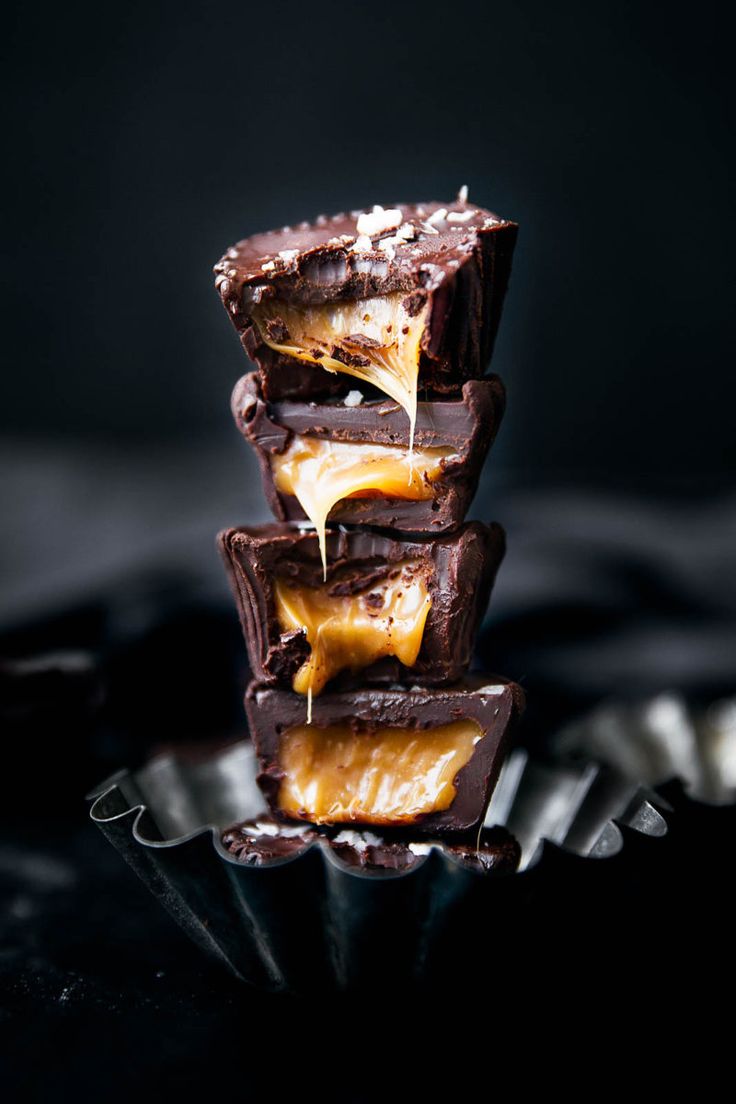 three pieces of chocolate and caramel are stacked on top of each other