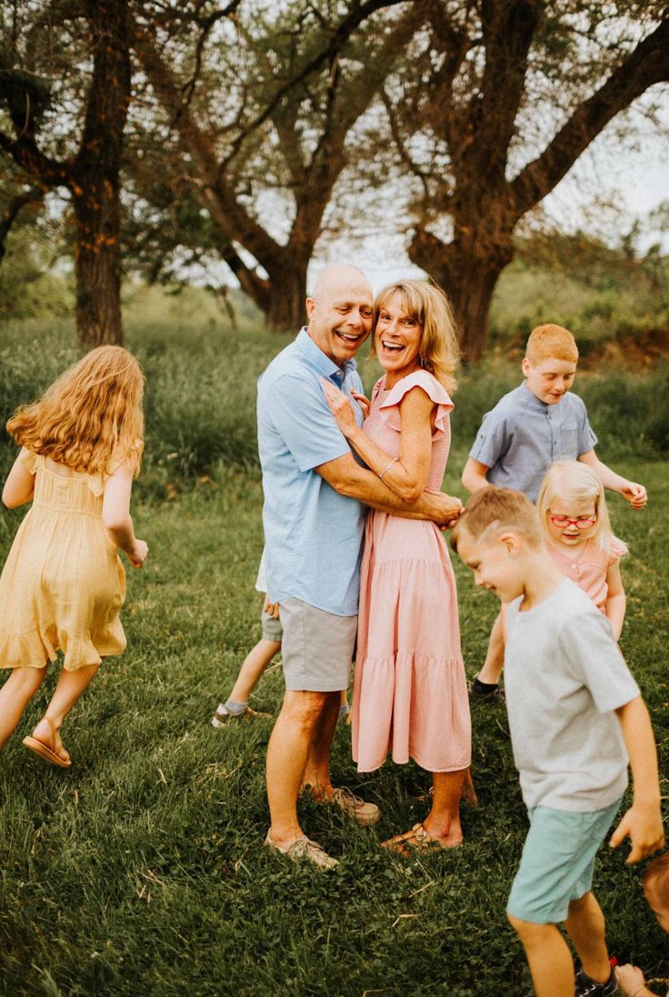 an older couple hugging their children in the grass