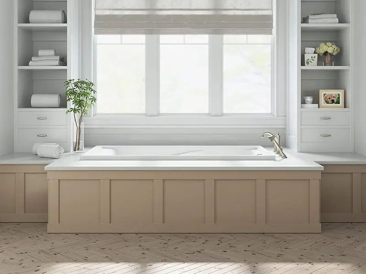 a large white bath tub sitting under a window next to a wooden shelf filled with towels