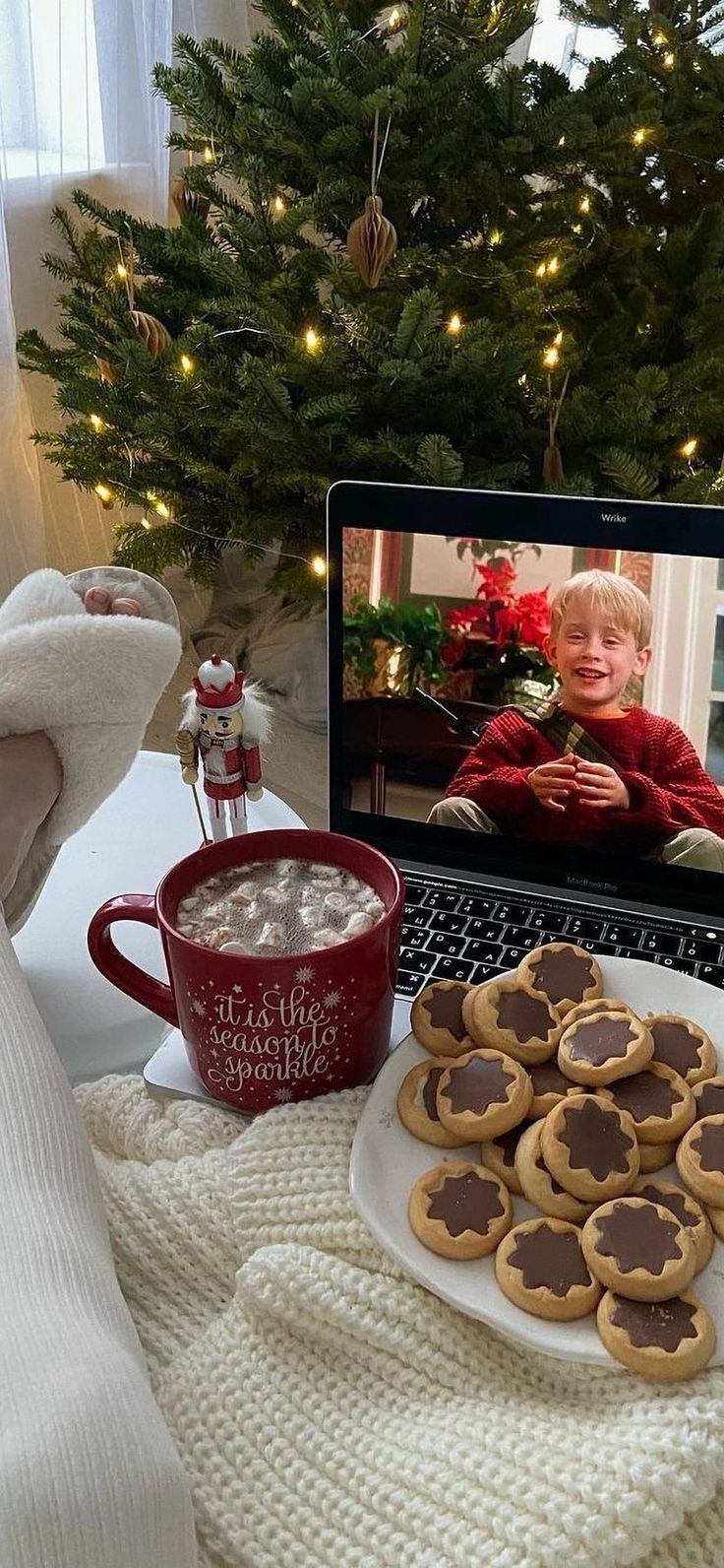 a laptop computer sitting on top of a table next to cookies and marshmallows