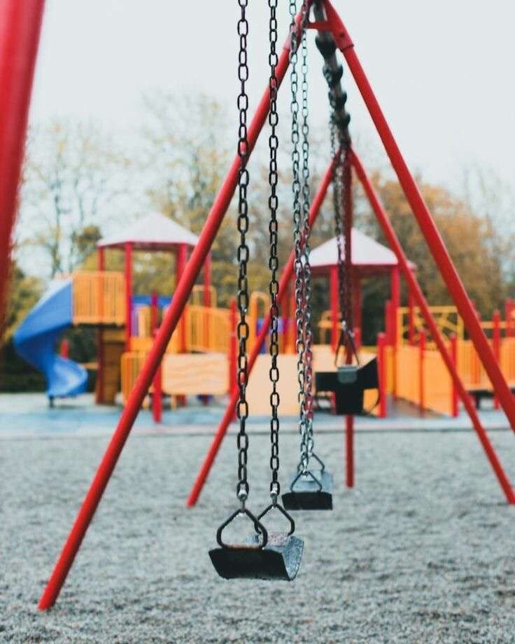 a swing set with swings and chains in a playground area for children to play on