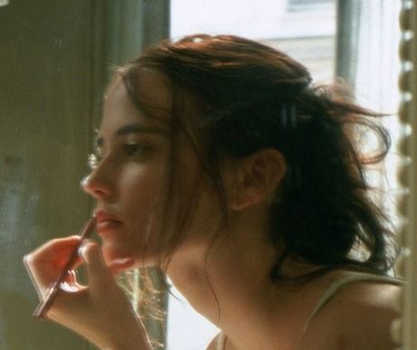 a woman brushing her teeth in front of a mirror