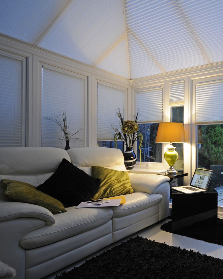 a living room filled with white furniture and windows