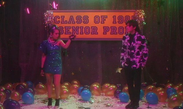 two people standing in front of a sign that says class of 1960 senior prom