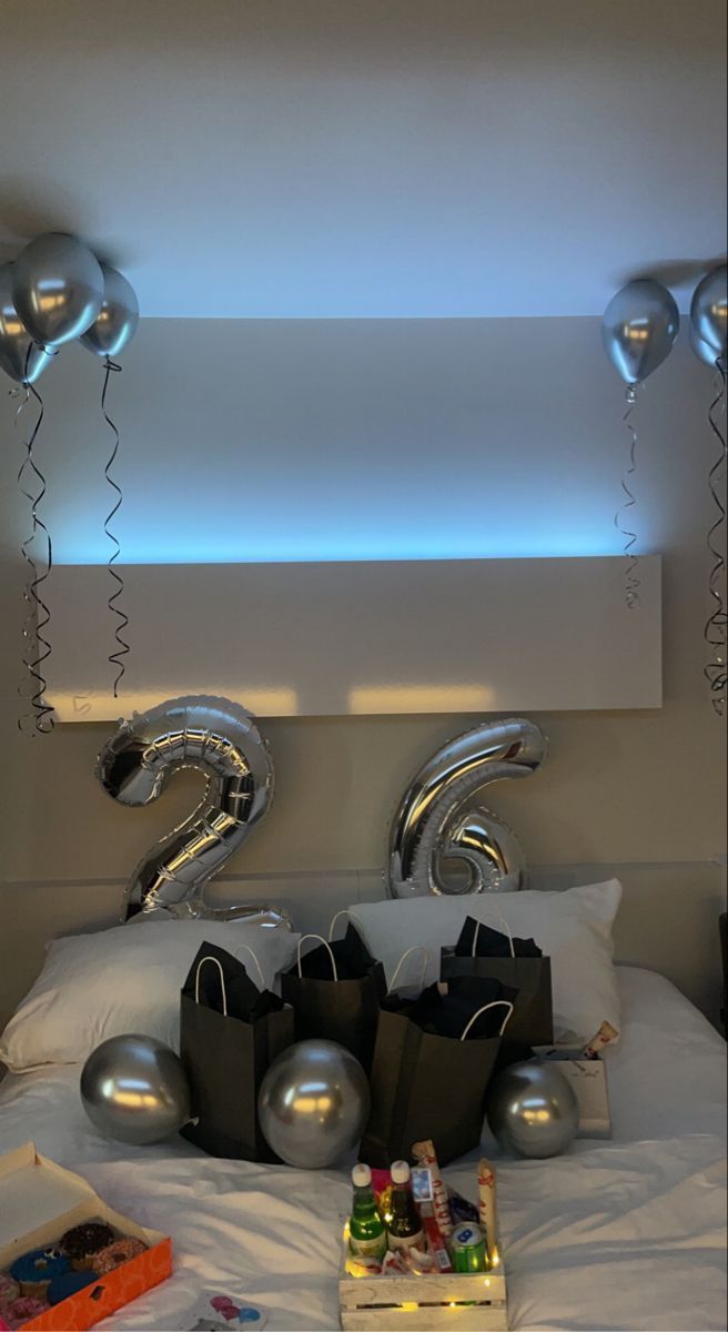 a bed with balloons and gifts on it