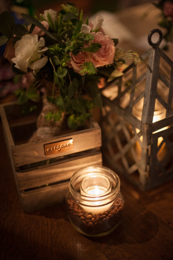 a candle and some flowers are on a table next to a vase with candles in it