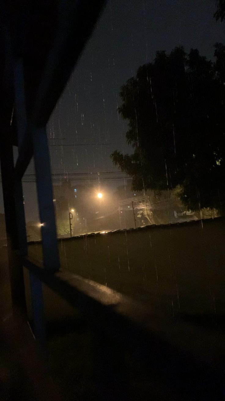 the street lights are shining in the rain at night time, and there is no image to describe