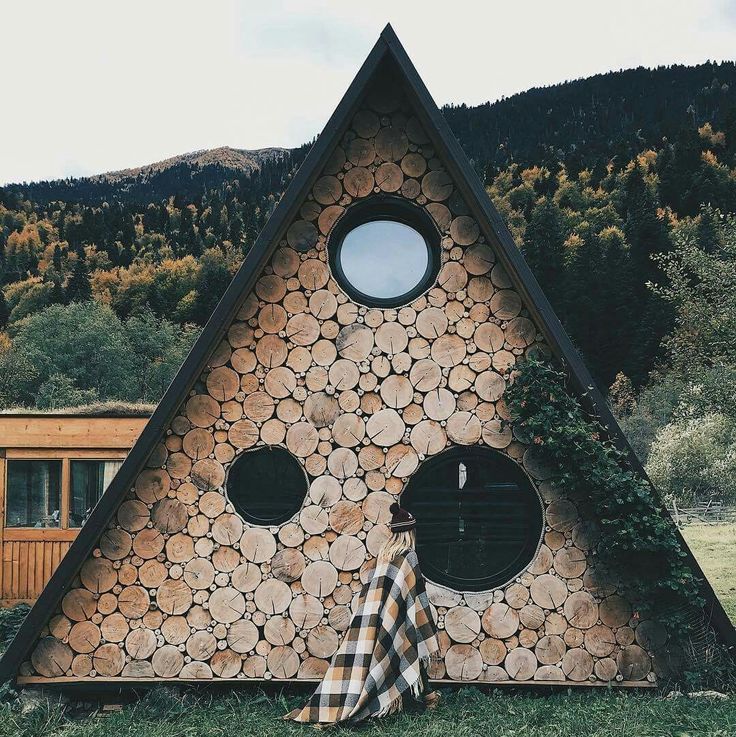 a house made out of logs with round windows