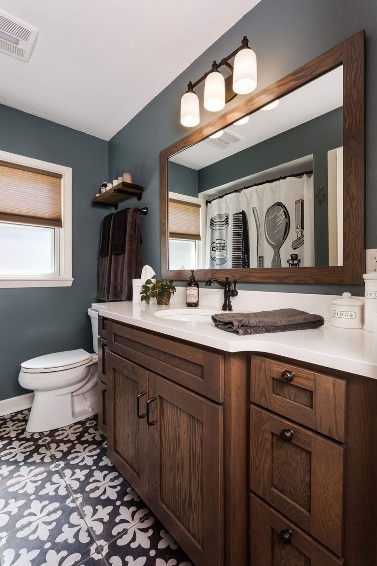 a bathroom with a toilet, sink and large mirror in it's center area