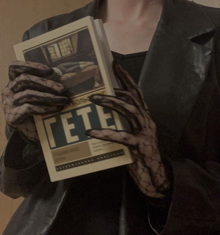 a woman wearing gloves and holding a magazine