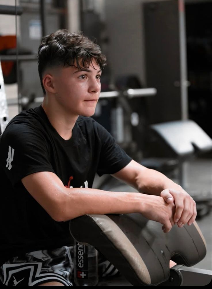 a young man sitting on top of a chair