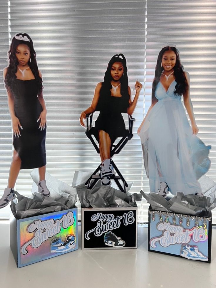 three barbie dolls sitting on top of boxes