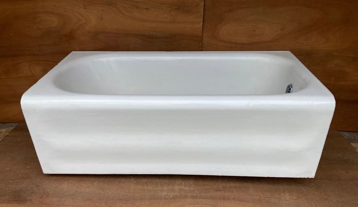 a white bath tub sitting on top of a wooden floor