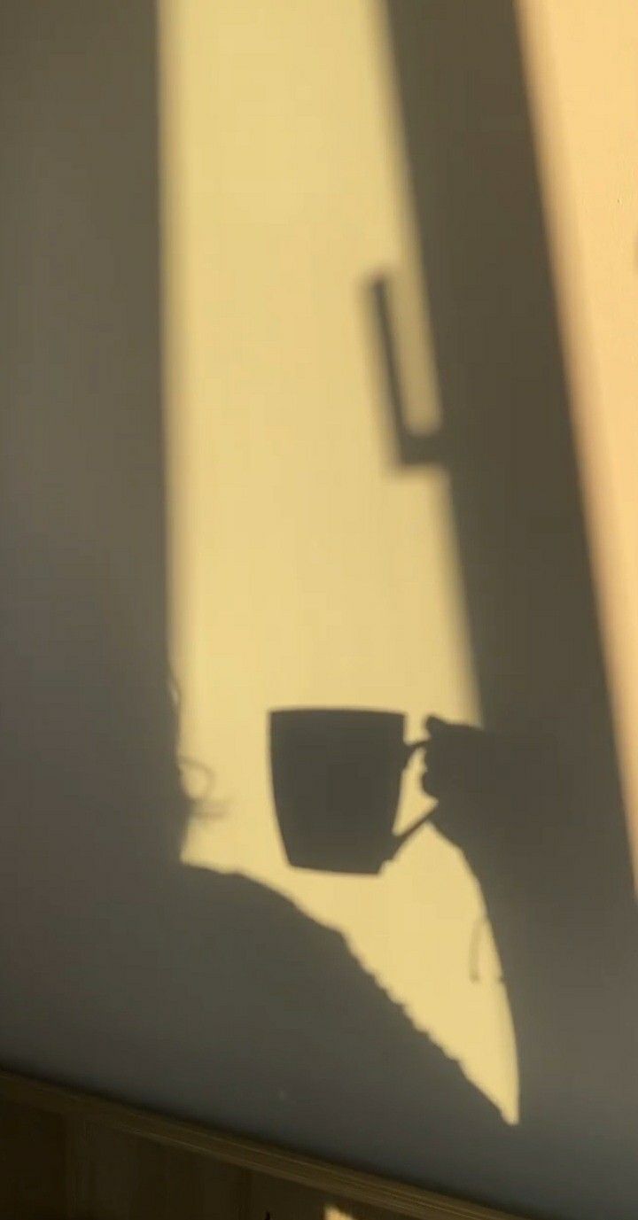 the shadow of a coffee cup on a wall