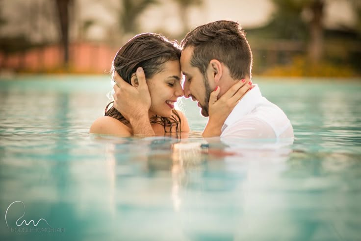 a man and woman are kissing in the water