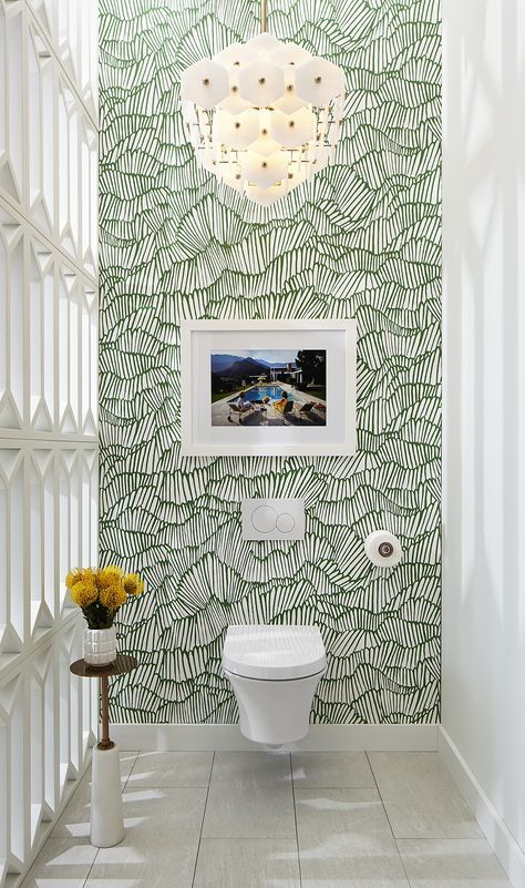 the bathroom is decorated in green and white with palm leaves on the wall behind it