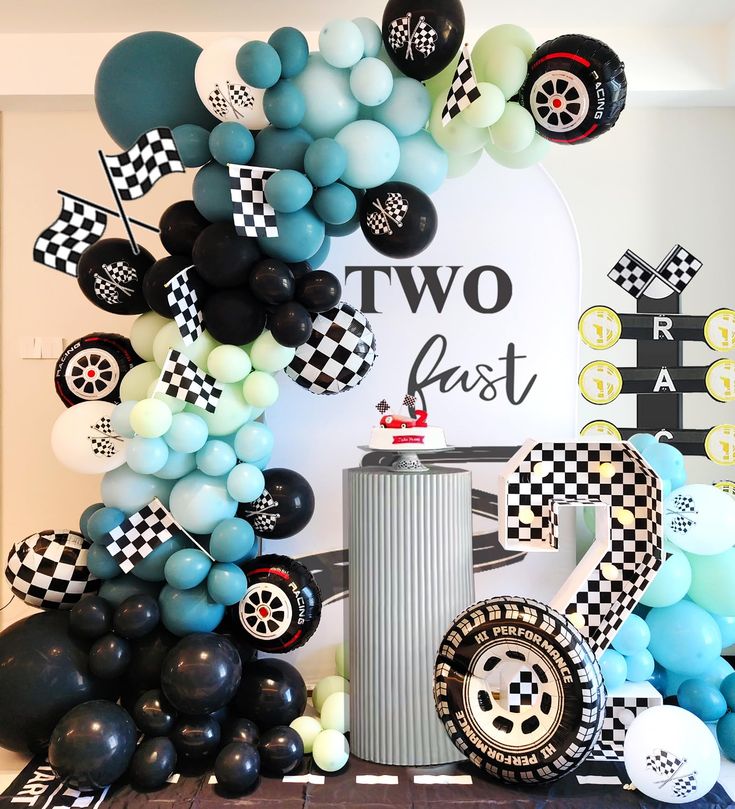 a car themed birthday party with balloons and race cars on the wall, including two fast wheels