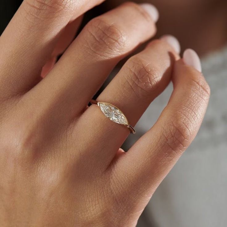 a woman's hand with a diamond ring on it