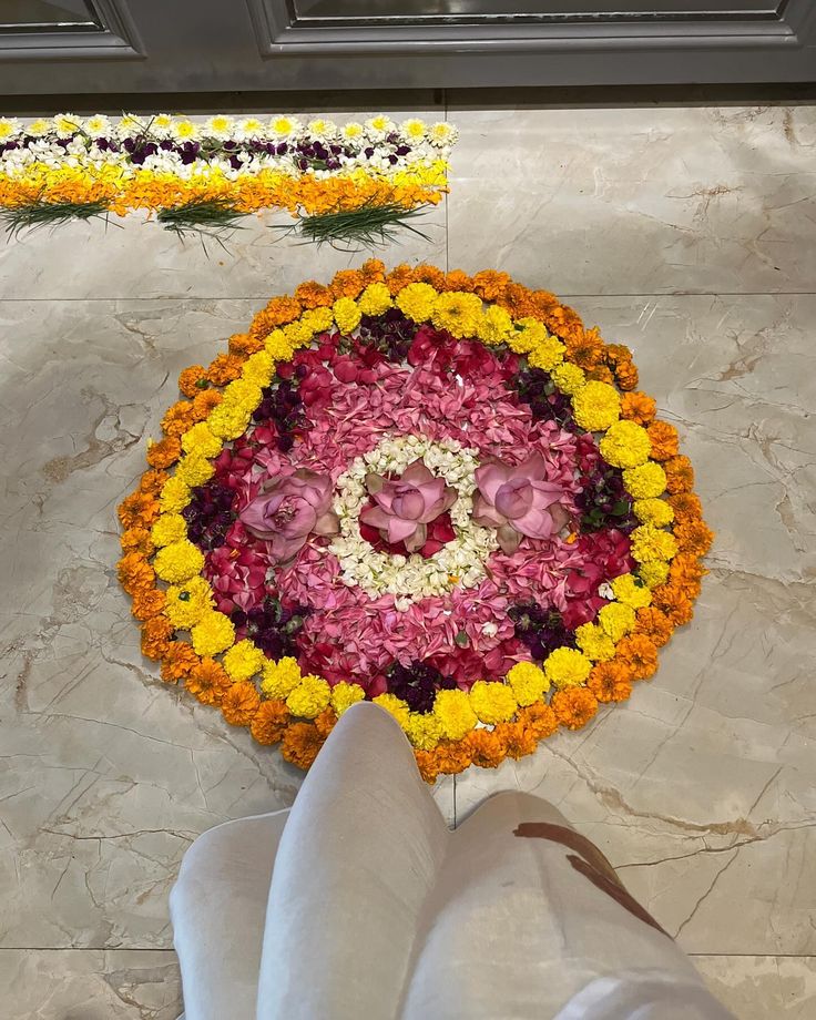 a person's feet standing in front of a flower arrangement that looks like an umbrella