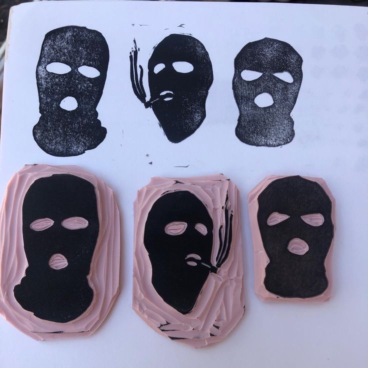 three masks are shown on top of a piece of paper with black and pink icing