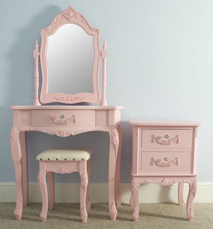 a pink vanity and stool in a room