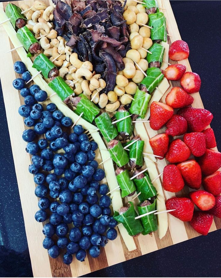 a wooden cutting board topped with fruits and veggies