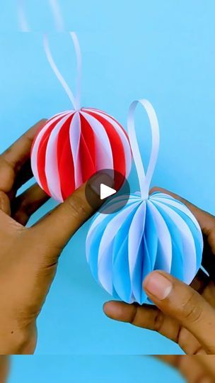 two hands holding origami hot air balloons