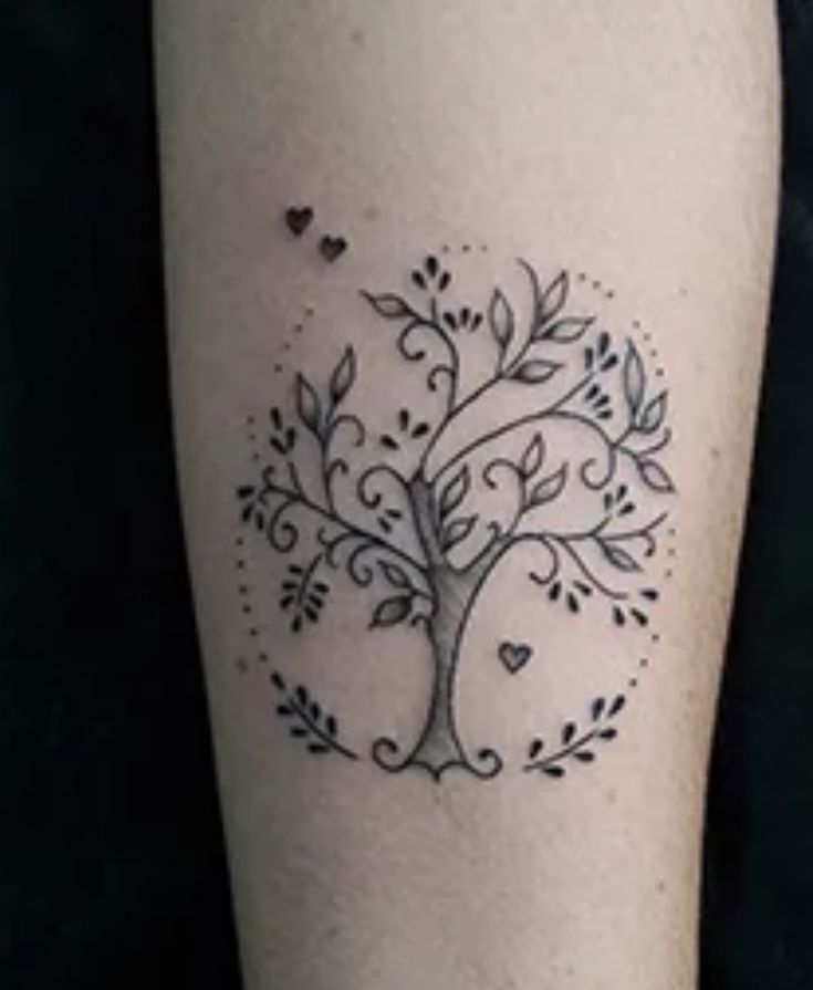 a tree tattoo on the leg with hearts around it and leaves in the shape of a heart