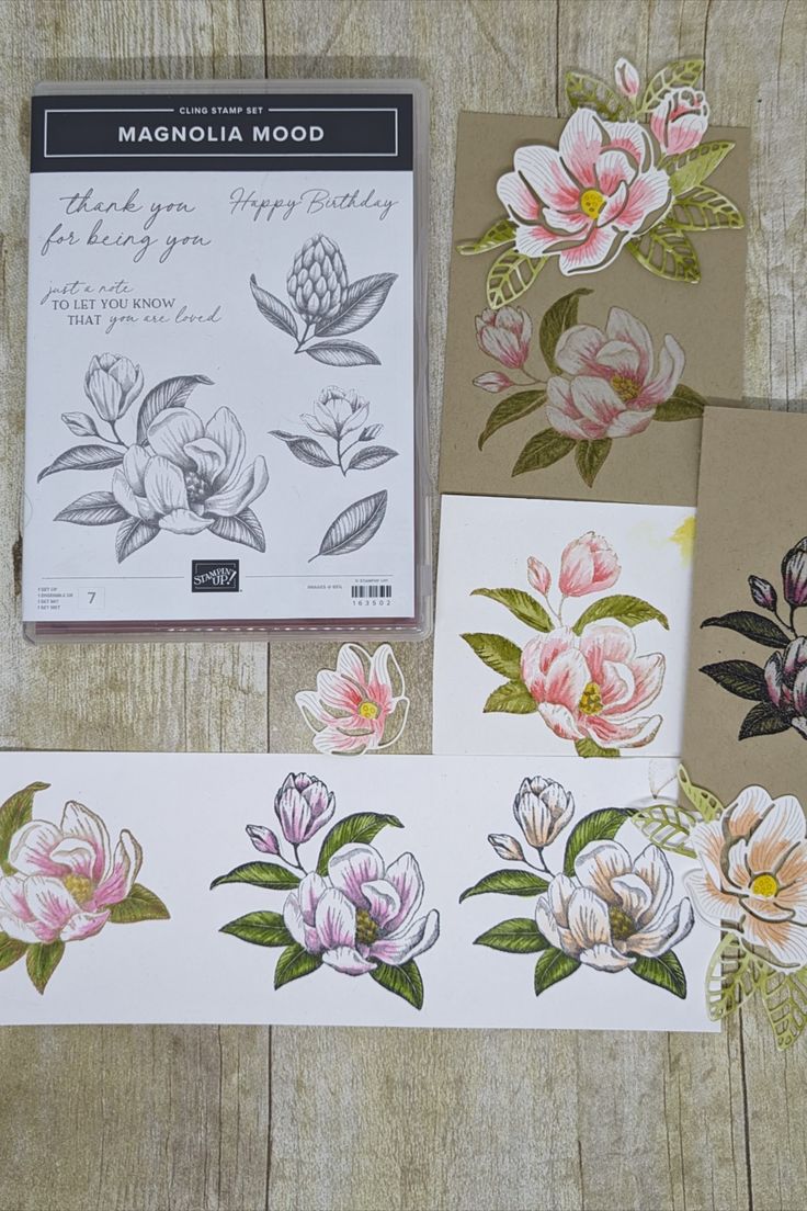 several cards with flowers on them sitting next to each other in front of a wooden table