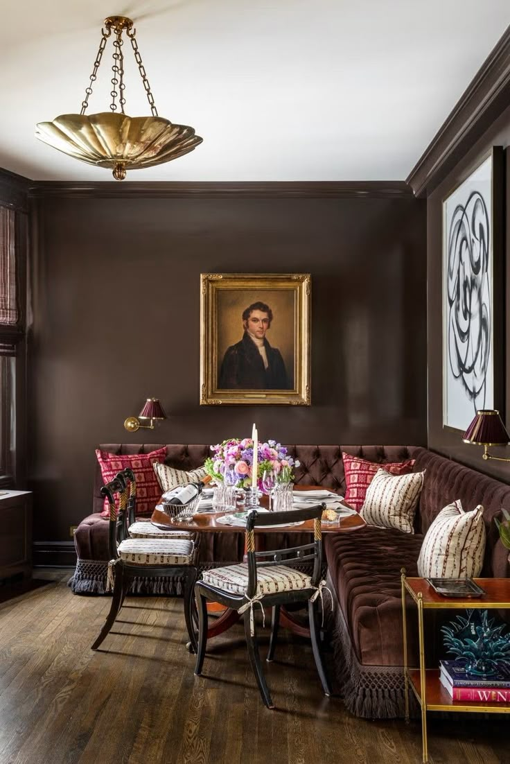 a living room filled with furniture and a painting hanging on the wall over a wooden floor