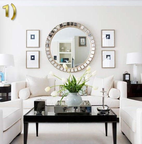 a living room filled with furniture and a mirror on the wall above it's coffee table