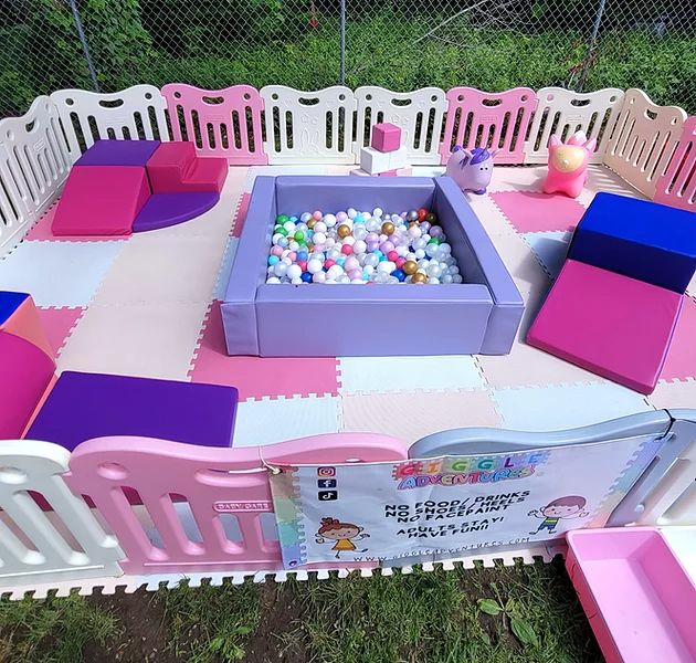 an outdoor play area with pink, purple and white furniture