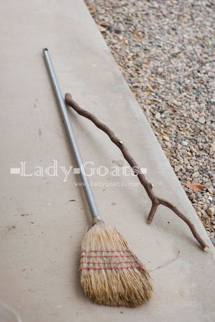 a broom sitting on top of a sidewalk next to a metal pole with a stick sticking out of it