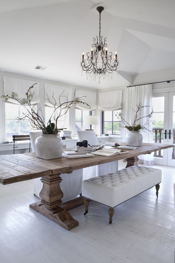 a dining room table with two benches and a chandelier hanging from the ceiling