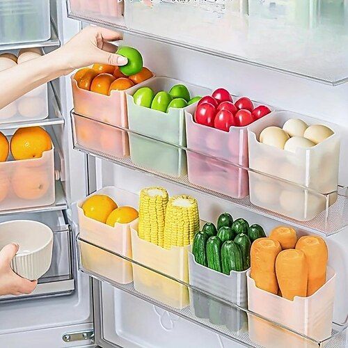 the refrigerator door is open and it has several bins filled with fruits and vegetables