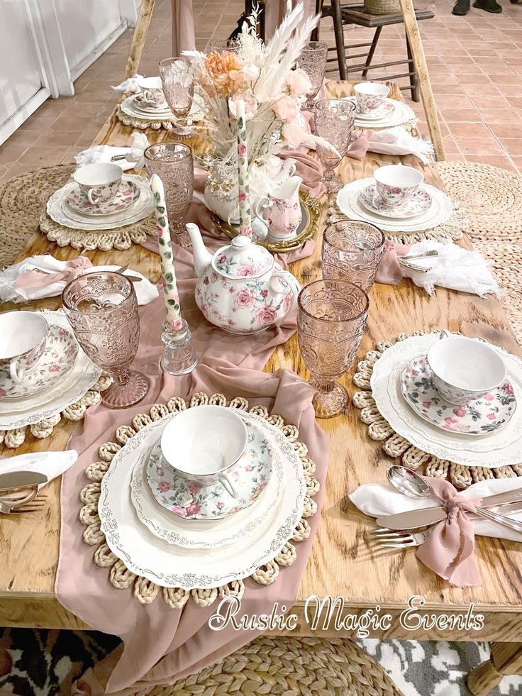 the table is set with pink and white china