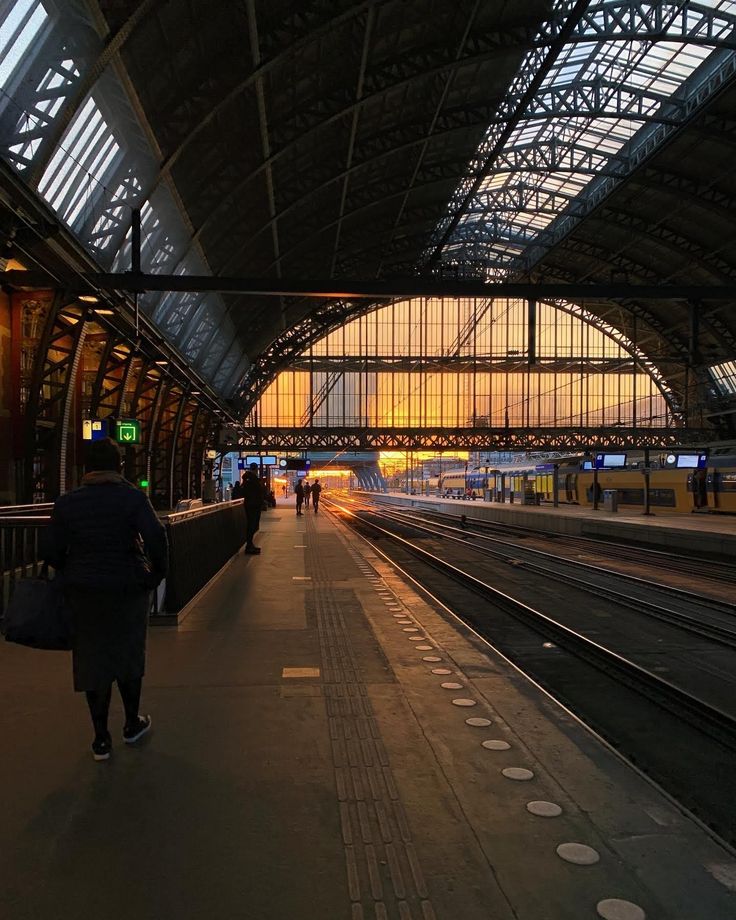 a train station with people walking on the platform