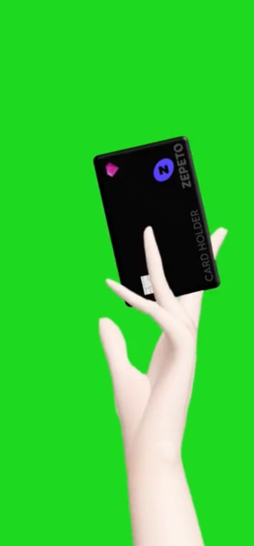 a hand holding an electronic device in front of a green background