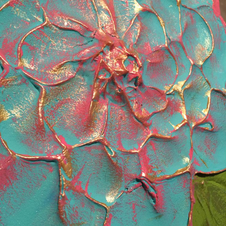 a blue and pink flower with green leaves on it's petals is shown in close up