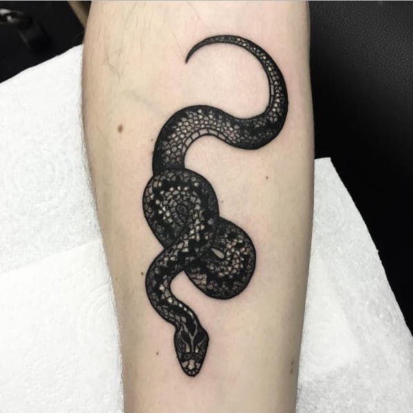 a black snake tattoo on the right arm and lower leg, it is curled up