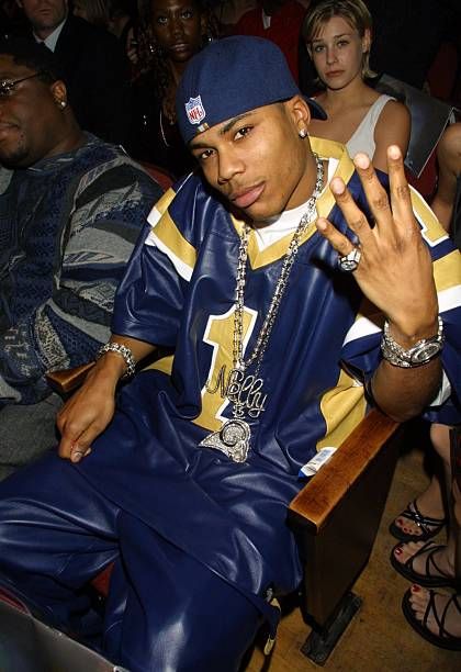 a young man sitting on top of a wooden bench in front of other people at a concert