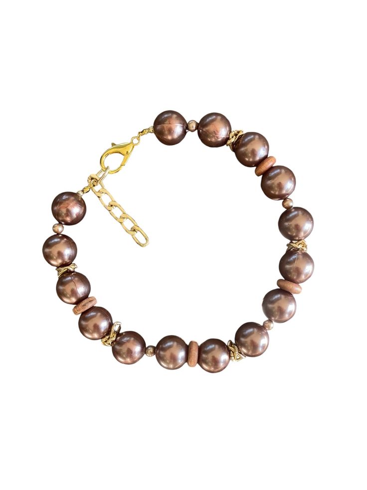 This exquisite chocolate pearl like beaded necklace is a statement piece. Featuring rich brown beads with a radiant luster, it's adorned with gold-toned accents that add an elegant and timeless charm. The adjustable chain ensures versatility and comfort, allowing you to wear it at your desired length. Handmade with attention to detail, this necklace is perfect for special occasions or to elevate your everyday look. Whether you're treating yourself or searching for a thoughtful gift, this piece w Brown Pearls Jewelry, Chocolate Pearls, Beaded Jewelry Necklaces, Brown Necklace, Necklace Elegant, Necklace Gold, Gold Accents, Statement Pieces, Thoughtful Gifts