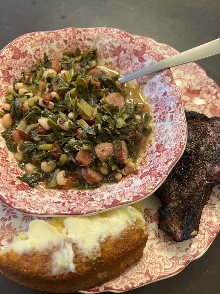 a plate with meat and vegetables on it next to a bowl filled with soup, bread