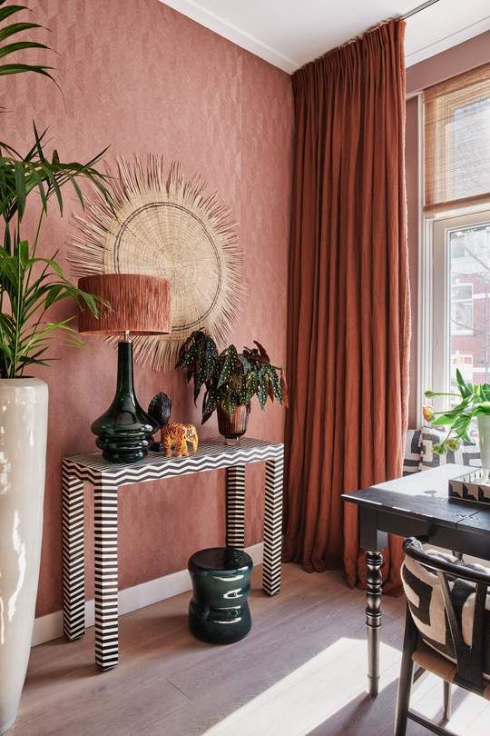 a living room filled with furniture and potted plants on top of a wooden table